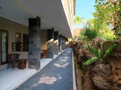 a hallway with a blue carpet with flowers on it at Sapta Petala Hotel in Kuta