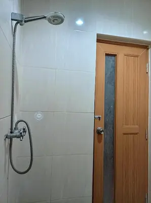 a shower in a bathroom with a shower head at Sapta Petala Hotel in Kuta