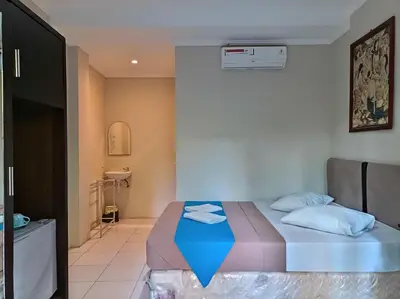 a bedroom with a bed with a blue blanket at Sapta Petala Hotel in Kuta