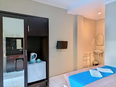 a small room with a bed and a television at Sapta Petala Hotel in Kuta