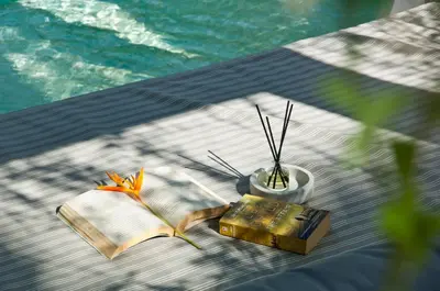 a table with a book and a vase and a book at Villa Alice by Villa Finder in Seminyak