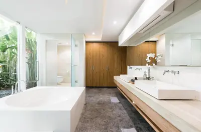 a white bathroom with two sinks and a shower at Villa Keila Seminyak in Seminyak