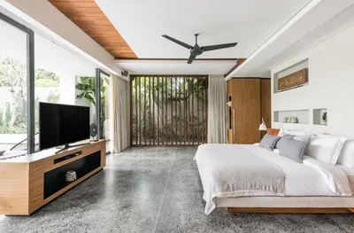 a bedroom with a large bed and a flat screen tv at Villa Keila Seminyak in Seminyak