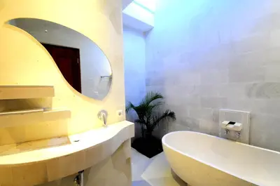 a bathroom with a sink and a mirror and a tub at Jas Boutique Villas in Seminyak