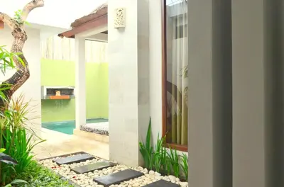a villa with a swimming pool and a house at Jas Boutique Villas in Seminyak