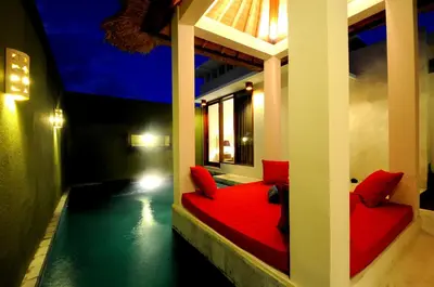 a room with a red bed and a pool at Jas Boutique Villas in Seminyak