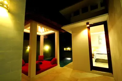 a room with a red couch and a mirror at Jas Boutique Villas in Seminyak