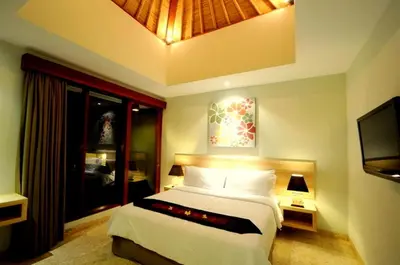 a bedroom with a large bed and a television at Jas Boutique Villas in Seminyak