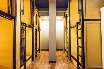 a hallway with yellow walls and a white pillar at Restu Bali Hotel in Legian
