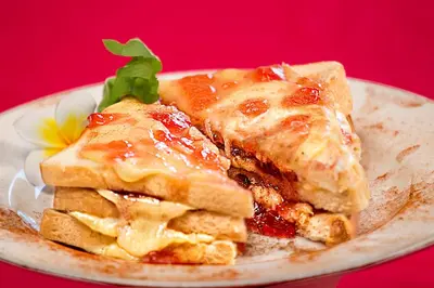 a plate of food with waffles on a red background at Restu Bali Hotel in Legian