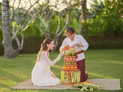 a woman and a girl are cutting a cake at The One Boutique Villa & Spa Seminyak in Seminyak