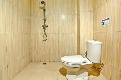 a bathroom with a toilet and a shower at KoolKost near Sunset Road Seminyak - Minimum Stay 30 Nights in Seminyak