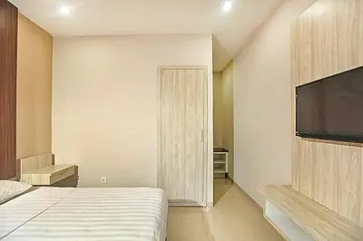 a bedroom with a bed and a flat screen tv at KoolKost near Sunset Road Seminyak - Minimum Stay 30 Nights in Seminyak