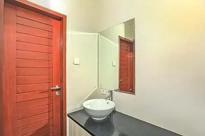 a bathroom with a white sink and a mirror at KoolKost near Sunset Road Seminyak - Minimum Stay 30 Nights in Seminyak