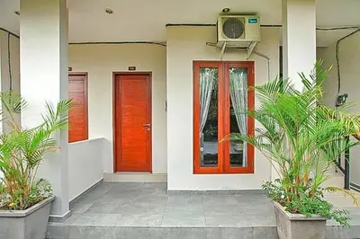 two red doors on a building with plants at KoolKost near Sunset Road Seminyak - Minimum Stay 30 Nights in Seminyak