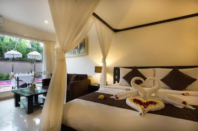 a bedroom with a bed with swans on it at The Yubi Boutique Villas Seminyak in Seminyak