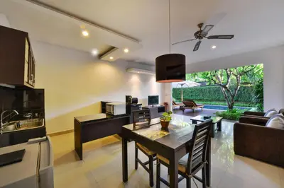 a kitchen and living room with a table and chairs at The Yubi Boutique Villas Seminyak in Seminyak