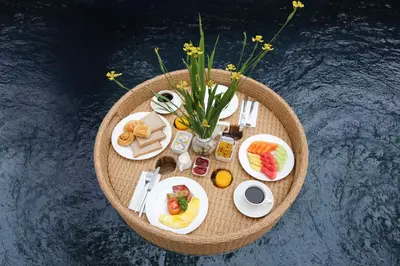 a round table with breakfast foods and flowers on it at The Yubi Boutique Villas Seminyak in Seminyak