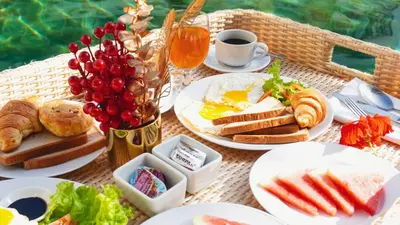 a table with plates of breakfast foods and drinks at Grand Kuta Hotel and Residence in Legian