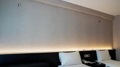 a white couch in a room with a large wall at Grand Kuta Hotel and Residence in Legian