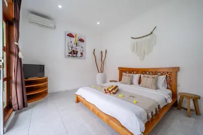 a bedroom with a large bed and a tv at Villa Jimmy in Seminyak