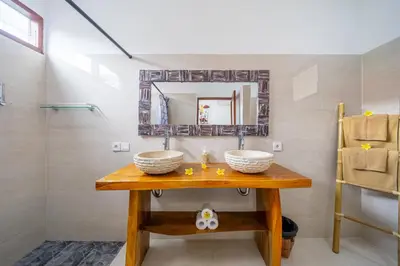 a bathroom with two sinks and a mirror at Villa Jimmy in Seminyak