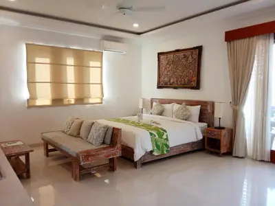 a bedroom with a bed and a couch and a window at ★ VIP ★ Green Studio Apartment in Seminyak, No.23 in Seminyak