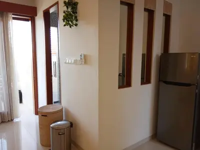 a kitchen with a refrigerator and two pictures on the wall at ★ VIP ★ Green Studio Apartment in Seminyak, No.23 in Seminyak