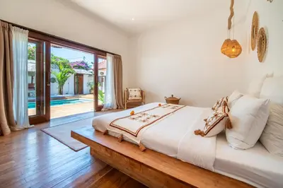 a bedroom with a large bed and a large window at Villa Makasih by Villa Finder in Seminyak