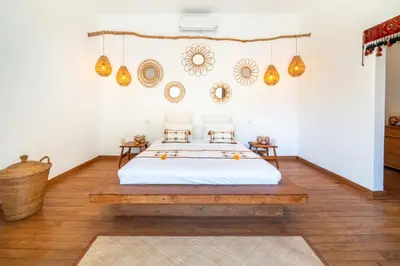 a bedroom with a bed and a wooden floor at Villa Makasih by Villa Finder in Seminyak