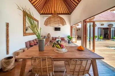 a dining room with a wooden table and chairs at Villa Makasih by Villa Finder in Seminyak