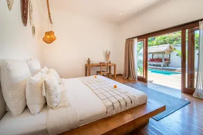 a bedroom with a bed and a sliding glass door at Villa Makasih by Villa Finder in Seminyak