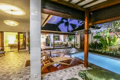 a house with a swimming pool and a living room at Villa Mira in Seminyak