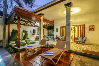 a living room with a patio with chairs and tables at Villa Mira in Seminyak