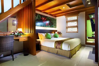 a bedroom with a bed and a desk in a room at The Banyumas Villa in Denpasar
