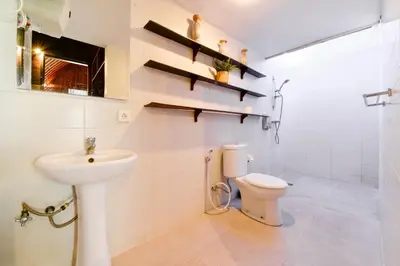 a bathroom with a toilet and a sink at The Lumbung Wood Villa in Seminyak