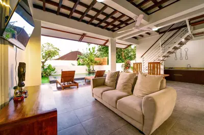 a living room with a couch and a table at The Lumbung Wood Villa in Seminyak