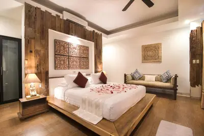 a bedroom with a large white bed and a couch at Sunset Paradise at Temple Hill Jimbaran in Jimbaran