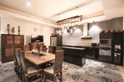 a kitchen with a wooden table and chairs and a counter at Sunset Paradise at Temple Hill Jimbaran in Jimbaran