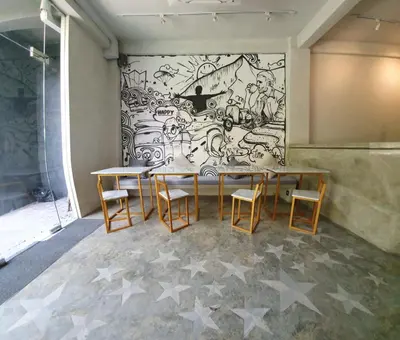a table and chairs in a room with a mural at Stellar Capsules in Seminyak