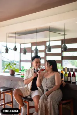 a man and a woman drinking wine in a bar at Grand Ixora Kuta Resort in Kuta