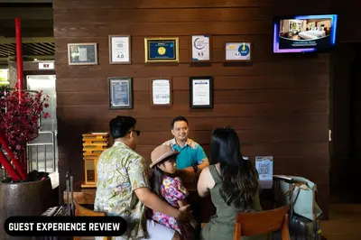a group of people sitting at a table in a restaurant at Grand Ixora Kuta Resort in Kuta