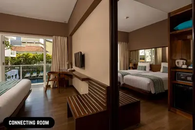 a hotel room with two beds and a balcony at Grand Ixora Kuta Resort in Kuta