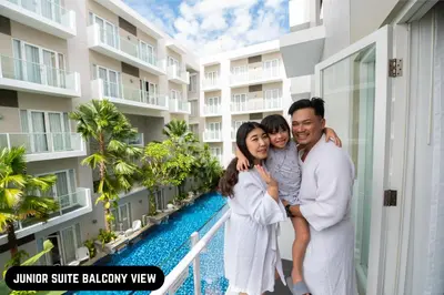 a family standing on a balcony of a building at Grand Ixora Kuta Resort in Kuta
