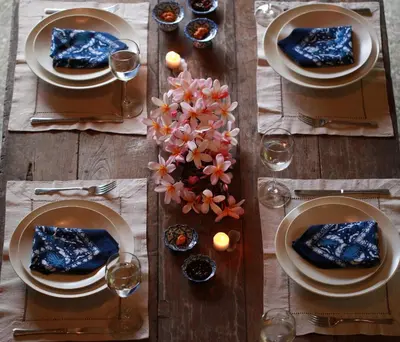 a wooden table with plates of food and wine glasses at Villas Sin Sin in Canggu