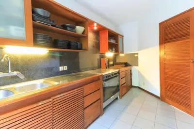a kitchen with wooden cabinets and a sink at Villas Sin Sin in Canggu