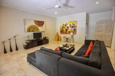 a living room with a couch and a tv at Bali Mystique Hotel & Apartment in Seminyak