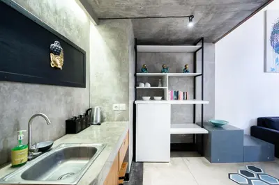 a small kitchen with a sink and a couch at Balissimo Suites Seminyak by Betterplace in Seminyak
