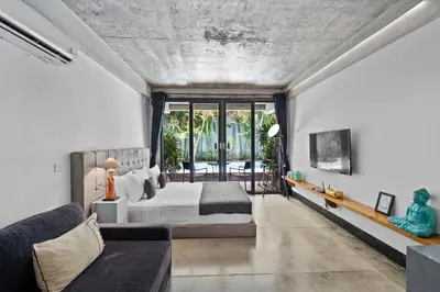a bedroom with a bed and a couch at Balissimo Suites Seminyak by Betterplace in Seminyak