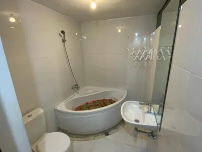 a white bathroom with a toilet and a sink at Bali Elephants Boutique Villa in Jimbaran